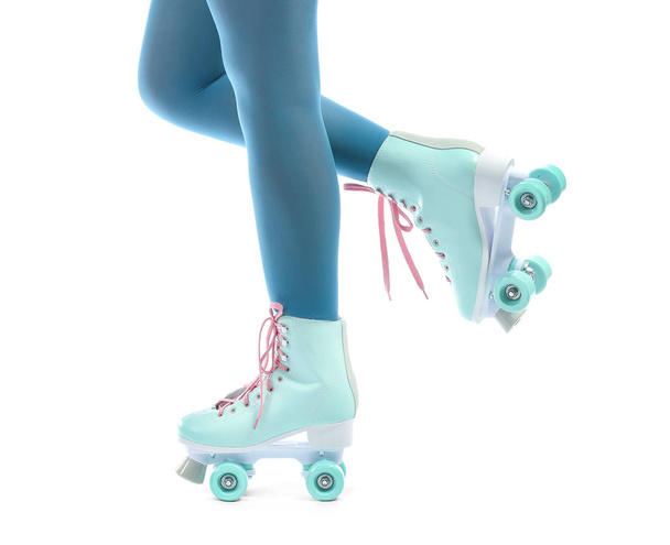 Legs of young woman on roller skates against white background - Fotoğraf, Görsel