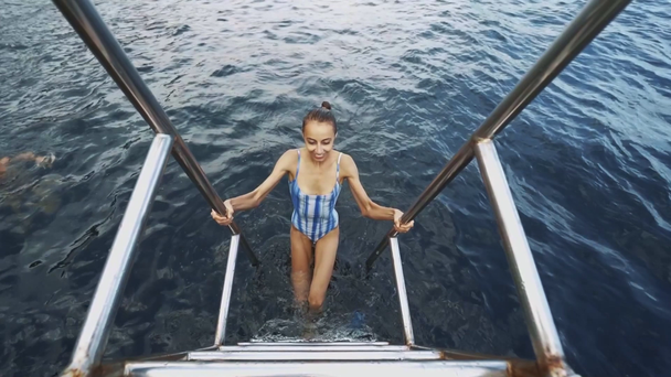 bela mulher feliz sexy esbelta em roupa de banho azul relaxante, nadando e desfrutando de água doce no lago da montanha no dia de verão ensolarado quente
. - Filmagem, Vídeo