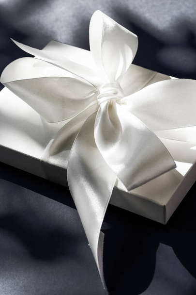 Scatola regalo bianca vacanza di lusso con nastro di seta e fiocco su nero
  - Foto, immagini