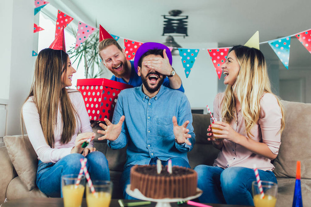 junge Gruppe von glücklichen Freunden feiert Geburtstag zu Hause und ha - Foto, Bild