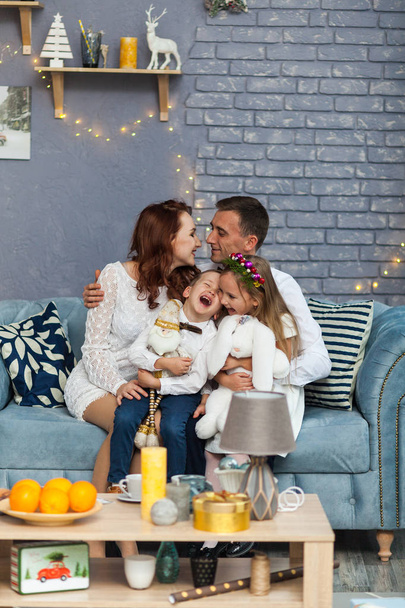 カメラ目線のクリスマス プレゼントを保持している幸せな家族 - 写真・画像