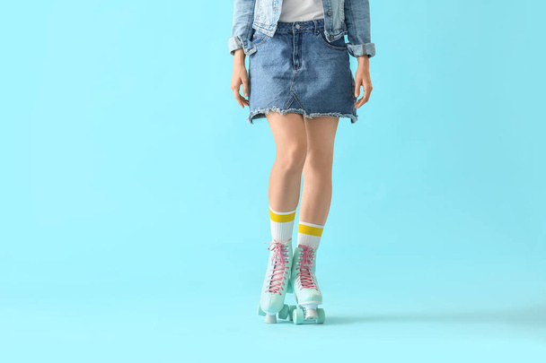 Beautiful young woman on roller skates against color background - Photo, image