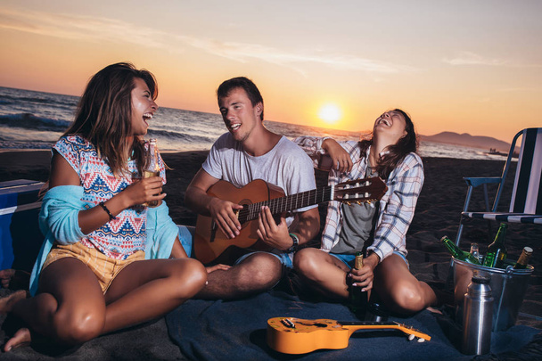 Glückliche Freunde feiern am Strand mit Drinks - Foto, Bild