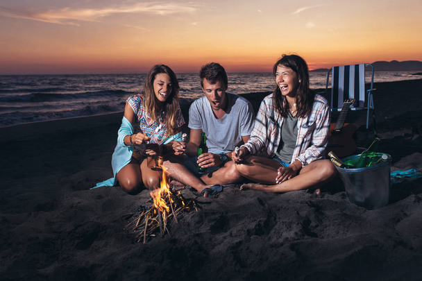 Glückliche Freunde feiern am Strand mit Drinks - Foto, Bild