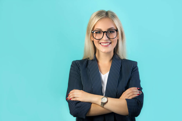 beautiful young woman in a black suit with glasses on a blue background - Photo, image