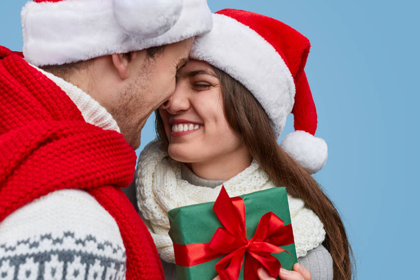 Cheerful couple exchanging Christmas gifts - 写真・画像