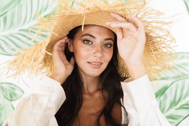 Photo closeup of alluring brunette woman in straw hat and beach  - Foto, imagen