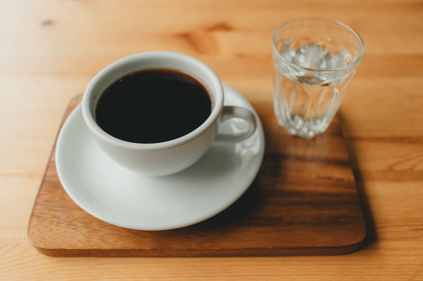 Hot cup of Americano coffee on wooden desk. - Foto, imagen