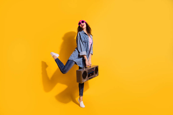 Full body photo of funky lady with big tape recorder in hands enjoy listening favorite song wear casual trendy clothes isolated yellow color background - Valokuva, kuva