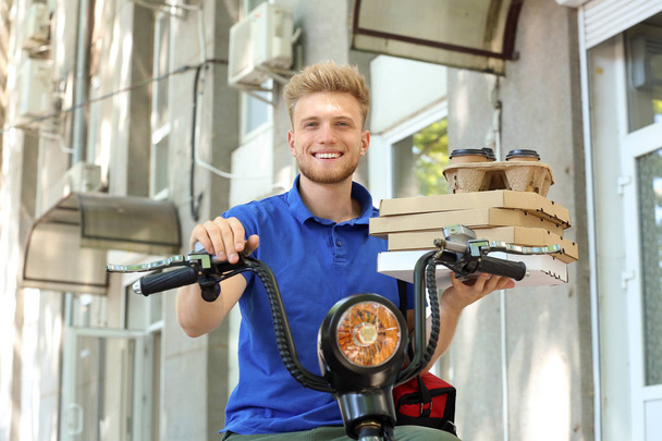Працівник служби доставки продуктів харчування водіння скутера на відкритому повітрі
 - Фото, зображення