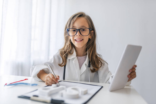 Child playing doctor with stethoscope in hands. Happy smiling kid girl playing at home or daycare. Education for preschool and kindergarten. Pediatric, healthcare and people concept. - Φωτογραφία, εικόνα