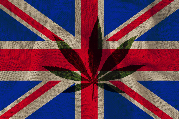 green leaf of hemp and the beautiful national flag of great britain, concept of medical cannabis, legalization of drugs, crime of drug dealers, close-up - Photo, image