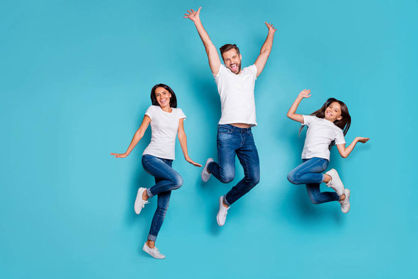 Full length body size photo of jumping enjoying nice glad family cute wearing white t-shirts jeans denim while isolated with blue background - Фото, изображение