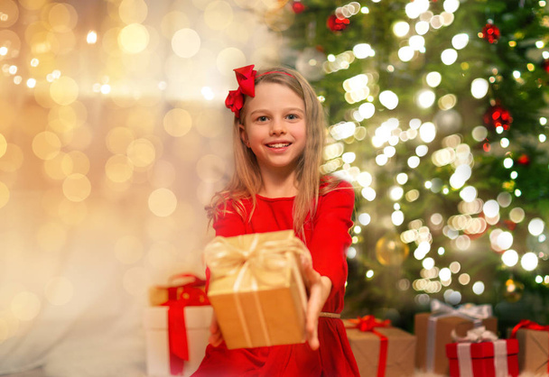 smiling girl with christmas gift at home - 写真・画像