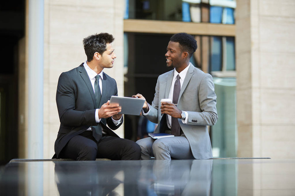 Zwei Geschäftspartner diskutieren gemeinsam Geschäftspläne mit digitalem Tablet im Freien - Foto, Bild
