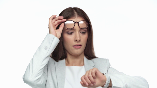 schöne Geschäftsfrau schaut auf Uhr isoliert auf weiß  - Filmmaterial, Video