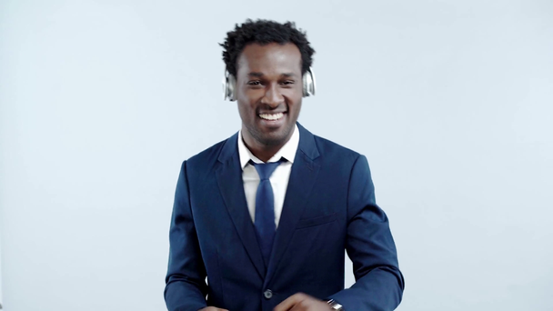 heureux homme d'affaires afro-américain dansant dans des écouteurs isolés sur gris
 - Séquence, vidéo