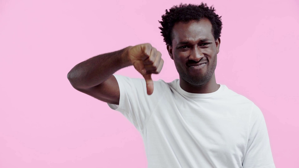 homem afro-americano descontente mostrando polegar para baixo isolado em rosa
 - Filmagem, Vídeo
