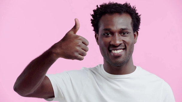 sonriente afroamericano hombre mostrando pulgar hacia arriba aislado en rosa
 - Imágenes, Vídeo