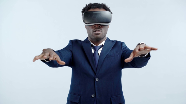 Afrikaans Amerikaans zakenman met behulp van vr headset en gebaren geïsoleerd op grijs - Video