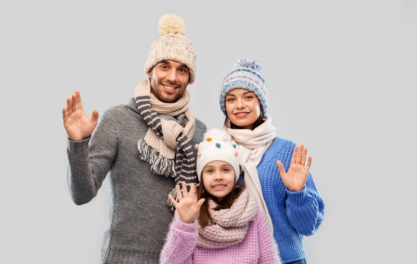 happy family in winter clothes waving hands - Foto, imagen