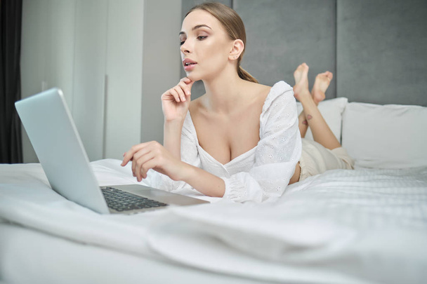 casual beautiful woman working on a laptop  on the bed in the ho - Photo, image