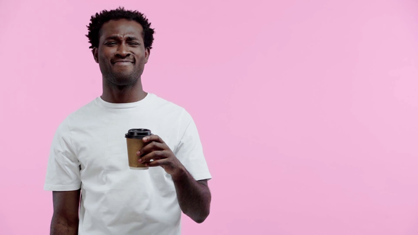 uśmiechnięty Afrykanin Amerykanin pijący kawę, by odizolować się na różowo - Materiał filmowy, wideo
