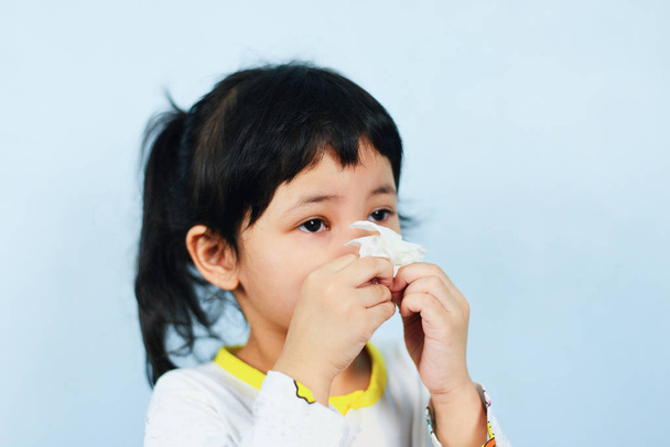 Азиатская маленькая девочка, больная завернутая в носовой платок остывает и дует
 - Фото, изображение