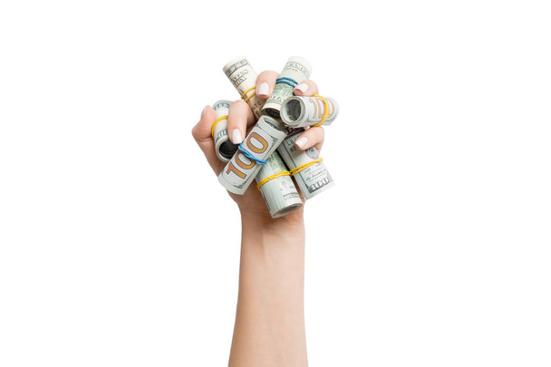 Top view of rolled up in tubes dollar bills in female palm on white isolated background. Poverty and debt concept with empty space for your design - 写真・画像