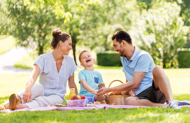 happy family having picnic at summer park - Fotografie, Obrázek