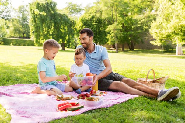 happy family having picnic at summer park - Foto, Bild