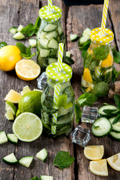 Glasses of lime, lemon soda drinks on wooden background - Fotó, kép