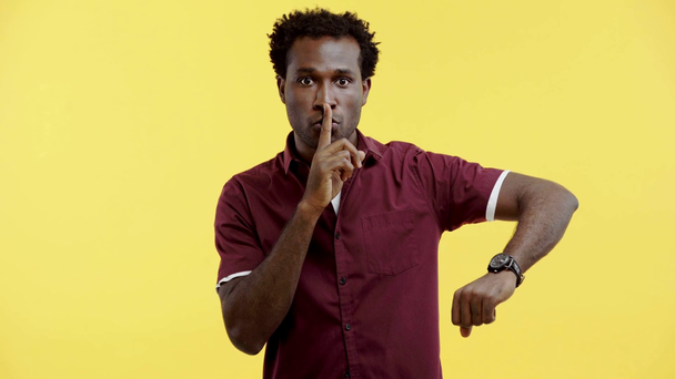 Серйозний афроамериканець з тихим знаком ізольований на жовтому - Кадри, відео