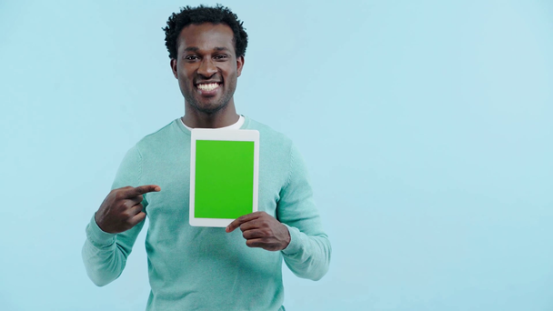χαρούμενα Αφρικής Αμερικανός άνθρωπος δείχνει ψηφιακή ταμπλέτα απομονώνονται σε μπλε - Πλάνα, βίντεο
