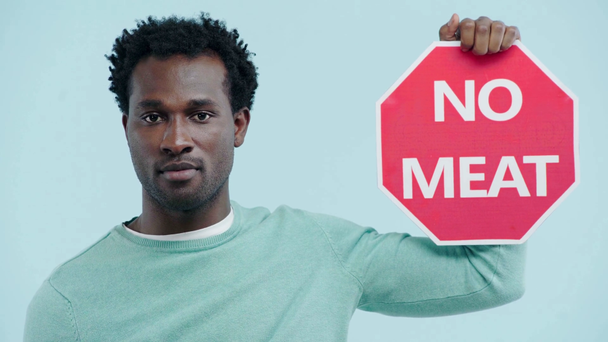 hombre africano americano confiado que no muestra ninguna tarjeta de carne aislada en azul
 - Metraje, vídeo