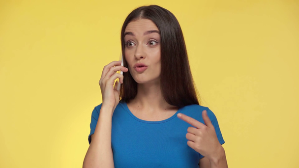 displeased woman talking and gesturing isolated on yellow - Footage, Video