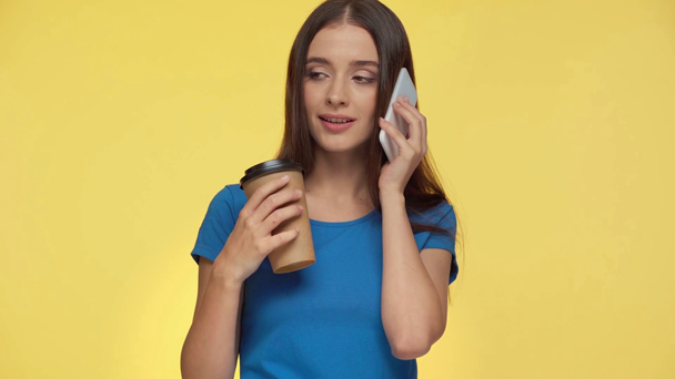 mulher atraente segurando copo de papel e falando isolado no amarelo
 - Filmagem, Vídeo