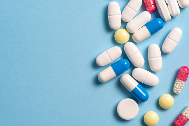 Estudio de toma de pastillas médicas sobre fondo azul
 - Foto, Imagen
