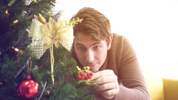 Caucasian man excited decorating Christmas tree and waiting to s - Valokuva, kuva