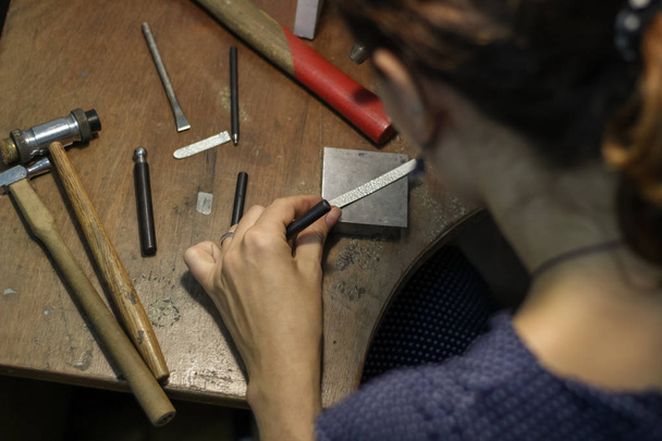 ジュエリーマスターは、銀のリングを作成するために働いています - 写真・画像