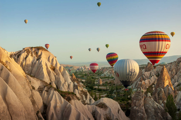 Heißluftballon fliegt über Felslandschaft in Kappadokien Türkei  - Foto, Bild