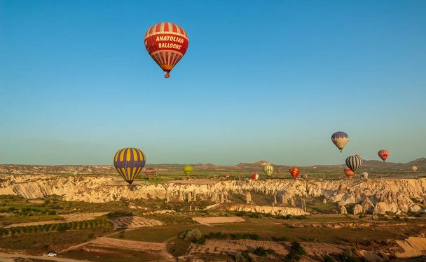 Αερόστατο που πετά πάνω από βραχώδη τοπία στην Καππαδοκία Τουρκίας  - Φωτογραφία, εικόνα