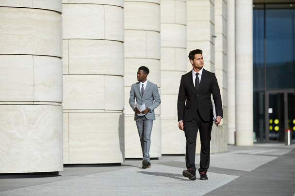 Gravi uomini d'affari fiduciosi che camminano lungo la strada - Foto, immagini