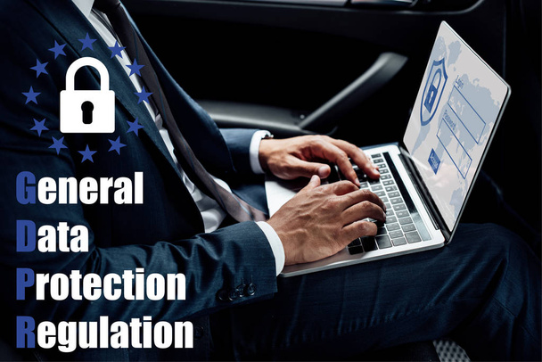 partial view of african american businessman using laptop in car with gbpr illustration - Photo, Image