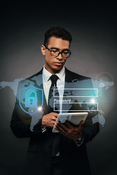 Afrikaans Amerikaans zakenman in bril met behulp van digitale tablet op donkere achtergrond met cyber security illustratie - Foto, afbeelding