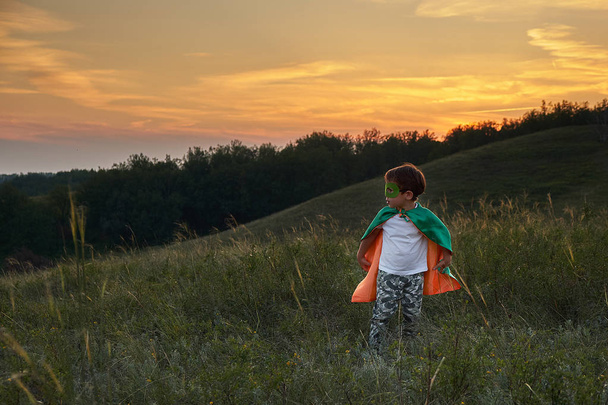 スーパーヒーローを演じる小さな男の子。スーパーヒーローの衣装を着た子供幸せな子供が走る - 写真・画像