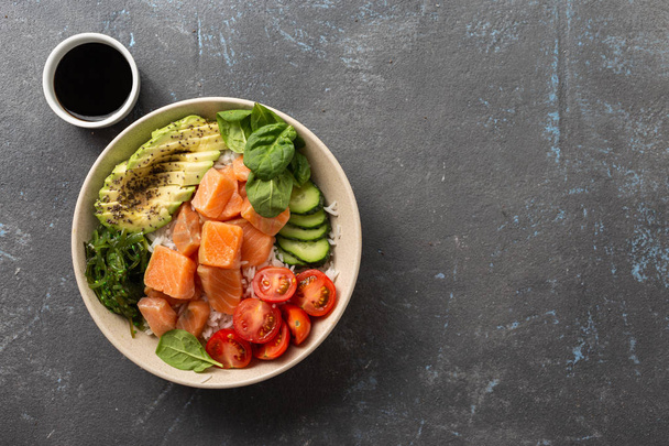 Tasty and healthy food concept Organic poke bowl with salmon, avocado, vegetables and chia seeds - Fotó, kép