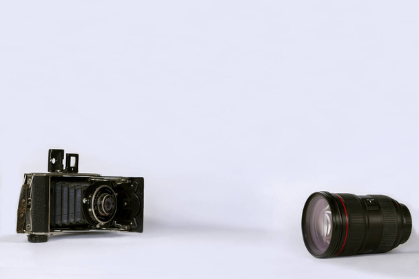    Antigua cámara vintage y lente moderna sobre fondo blanco. Para agregar texto .Primer plano
. - Foto, imagen