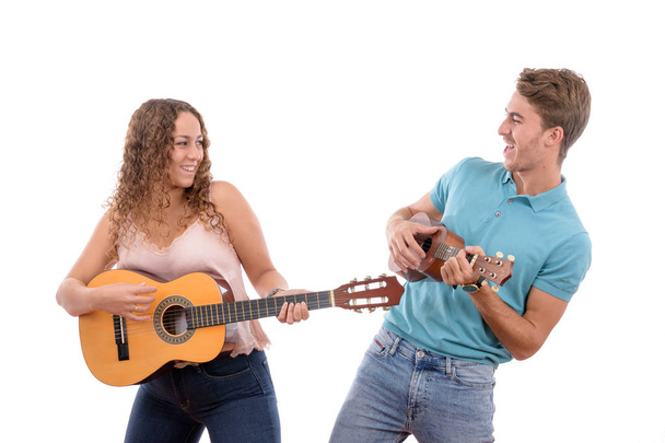 δύο νεαροί Καυκάσιοι αδελφοί ή ζευγάρι να παίζουν κιθάρα και ένα γιουκαλίλι να διασκεδάζουν μαζί σε ένα πάρτι με λευκό φόντο απομονωμένο - Φωτογραφία, εικόνα