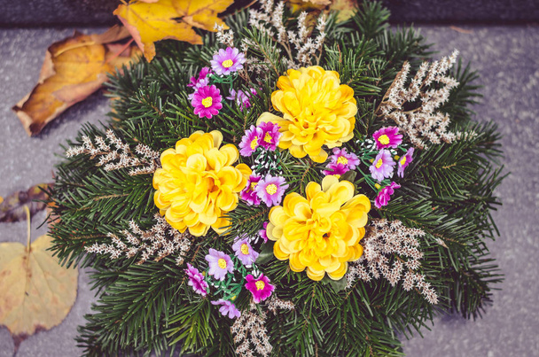 Осінній квітковий декор на могилі під час Дня всіх святих на кладовищі. - Фото, зображення
